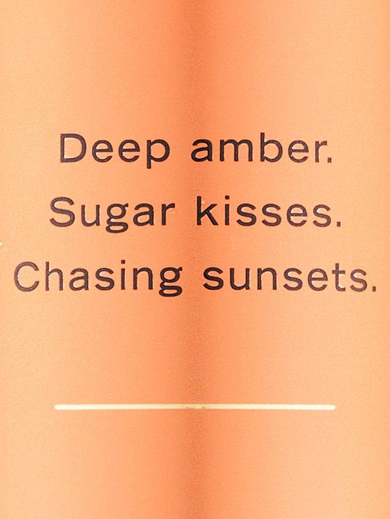 بطری لوسیون بدن Amber Romance ویکتوریا سکرت در کنار جعبه‌ی اصلی برند