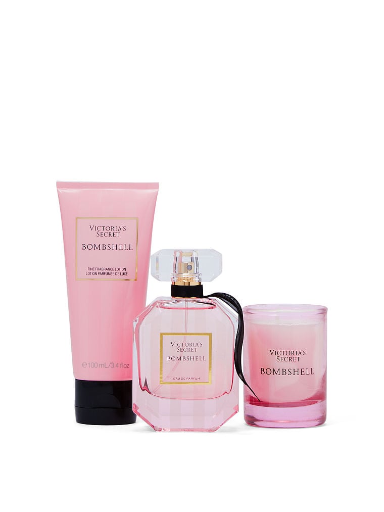 چیدمان عطر و لوسیون پک Bombshell ویکتوریا سکرت کنار شمع روشن